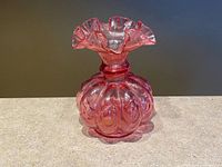 Front view of cranberry glass vase showing melon ribs and ruffled rim
