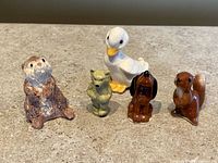 All five miniature animal figurines standing on countertop