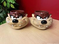 Front view of both Taz mugs displaying sculpted faces