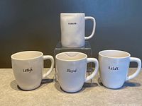 All four mugs displayed; CREATE elevated, LAUGH, BLESSED, RELAX front