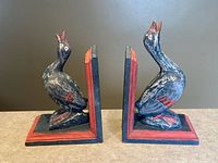 Front angled view of both wooden duck bookends showing carved detail and paint wear