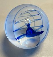 Front view of spherical blue Caithness paperweight showing internal design and frosted surface.