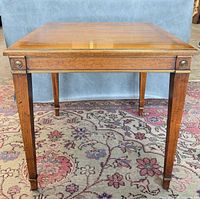 Front angle of wooden side table showing brass trim and legs