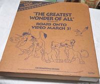 Front of cardboard promo kit showing characters and release slogan