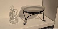 Cruet beside frosted bowl on metal stand