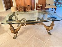 Oblique view of entire coffee table showing glass top and mermaid legs