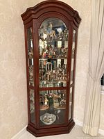 Full view of cherry veneer corner curio cabinet with glass panels