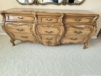 Front view showing full dresser, seven drawers, carved details, brass-tone handles