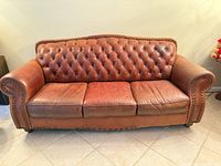 Front view of full sofa showing overall design, tufted back, rolled arms, nailhead trim