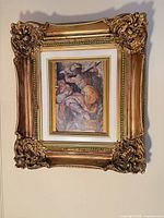 Entire framed print hanging on wall showing ornate gold frame