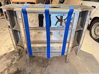 Front view showing mirrored finish, three drawers, open side shelves