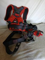 Front view of 3M Protecta red and black safety harness showing straps, buckles, and branding