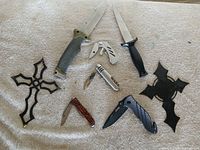 All six knives and multitool arranged on surface
