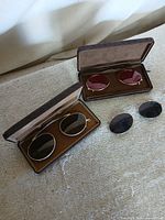 Two clip-on sunglasses in cases plus one loose clip-on pair