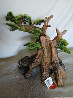 Full view of resin bonsai tree ornament showing trunk, branches, foliage and rock base