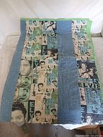 Full view of quilt showing Elvis panels, blue dotted strips and green binding
