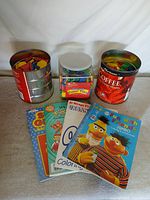 Group shot: 4 coloring books, Lauri Color Tiles jar, 2 coffee cans with foam tiles