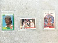 Front view of all three trading cards in holders