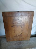 Front view of entire oak plaque showing carved portrait and framed border