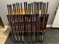 Full view of 28 steel golf shafts standing upright with grips