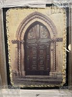 Close view of relief artwork showing arched doorway and texture