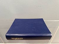 Closed blue binder with gold "Majesty" on spine