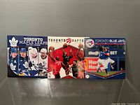 Front covers of three sealed calendars: Maple Leafs, Raptors, Blue Jays
