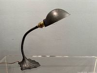 Profile view of lamp showing cast iron base, gooseneck, shade