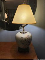 Full view of lamp with shade on wooden surface