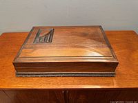 Closed wooden chest showing lid and emblem
