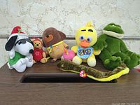 Front view of all six plush toys lined up on table