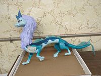 Full side profile of Sisu dragon figure showing overall size and coloration