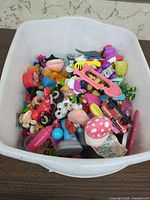 Bin containing large assortment of small toys and parts