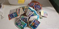Loose stacks of mixed football and baseball cards on table