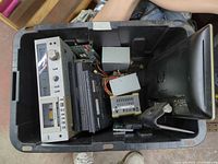 Overview of bin showing Technics deck, laptops, power supplies, HP monitor