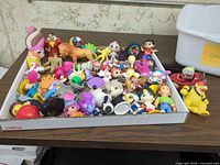 Overview of tray filled with assorted small plastic toys