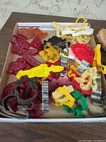 Overview of box containing mixed metal and plastic cookie cutters