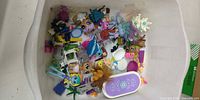 Overhead view of bin with all mixed dolls, figures and accessories