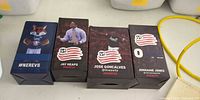 Front view of four New England Revolution bobblehead boxes