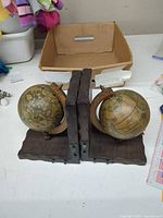 Front view of both wooden globe bookends side by side