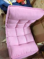 Front angled view of pink tufted floor lounge chair cushion