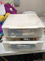 Two-drawer translucent organizer with drawer open showing circuit boards