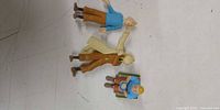 All three Tintin figurines laid out showing scale and overall wear
