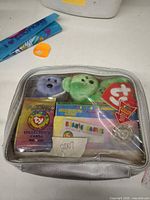 Entire lot inside clear-front case showing plush toys, card packs and coin