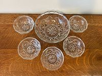 Top view of serving bowl and five matching bowls displaying starburst pattern