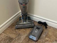 Vacuum head, battery charger and cord on floor