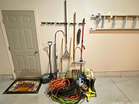 Overall view of lot showing long-handled tools, hoses, cords, boots and accessories