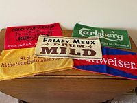 Five of the eight vintage advertising bar towels displayed on table