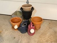 Group of garden planters and watering cans showing all items together