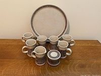 Front view showing platter, six mugs, lidded sugar bowl